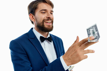 happy man with bundle of money and in classic suit on white background cropped view