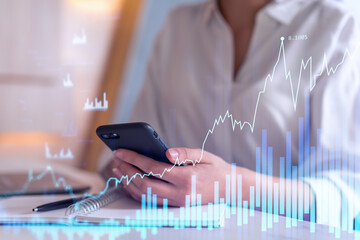 A woman trader holding in the hands a smart phone and researching stock market to proceed right investment solutions. Internet trading and wealth management concept. Hologram Forex chart.