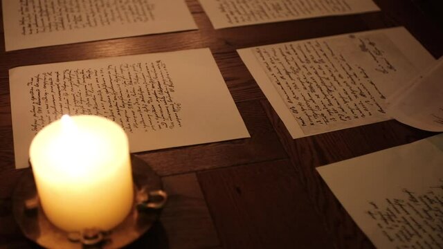 writer woman in night shirt is writing poem in a dark room with a candle light