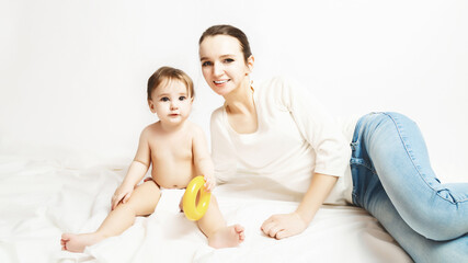 Happy mother playing with baby on bed