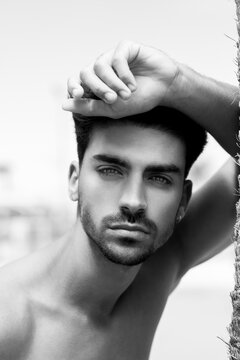 Retrato en blanco y negro de hombre hispano, joven y guapo con barba. Modelo con mirada seductora