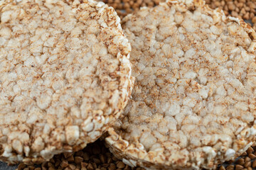 Two rice cakes and uncooked buckwheat in close up view