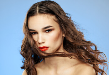 Woman on a dim background with long hair and red lips model makeup