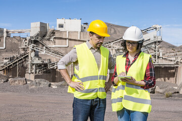 Engineers with tablet communicating on construction site