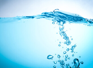 The flow of water creates a splash and the blue waves underwater, and the bubbles naturally flow to the surface. with copy space