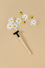 Daisy and garden rake creative minimal background. Neutral beige table flat lay. Garden, floral, season concept