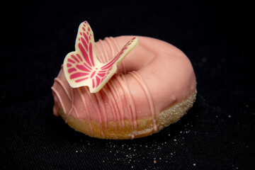 beautiful donut covered with pink chocolate and decorated with a beautiful butterfly 