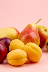 Fototapeta na wymiar Pears,apricot, cherries on pink background