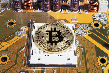 golden bitcoin on a computer motherboard, close-up