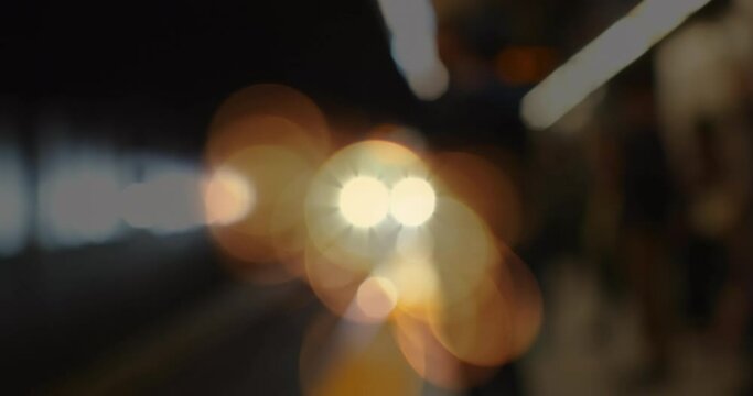 Animation of glowing spots of light flickering over out of focus train platform