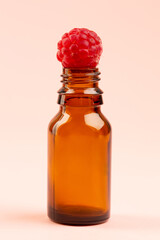 Raspberry on small bottle on pink background 