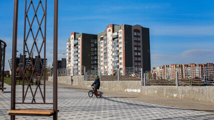 Cityscape. Apartment buildings. Child on a bicycle. Ust-Kamenogorsk (Kazakhstan). 2020.