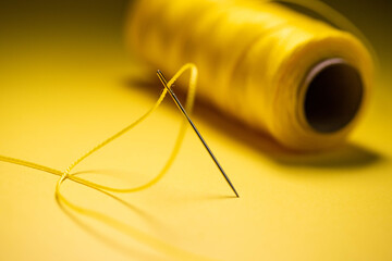 yellow thread in a needle