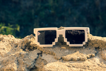 Green pixel sunglasses with black lenses closeup in a sunny day. Selective focus. High quality photo