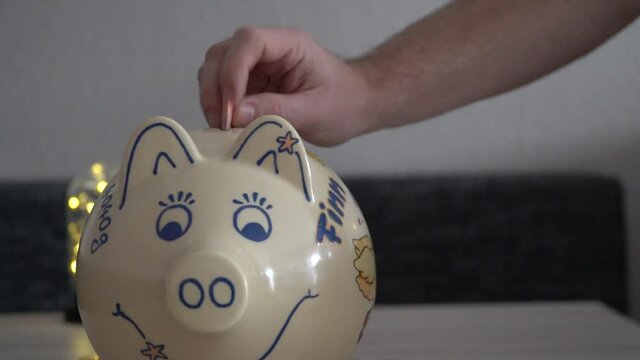 Geld in ein Sparschwein f&uuml;llen
