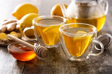 Ginger tea with lemon and honey in crystal glass on wooden table