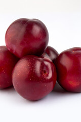 Red round plum on white background
