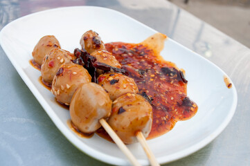 Meatballs with spicy dipping sauce in white plates, Thai street food