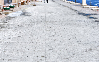 White salt stains on pedestrian paving slabs. Salty surface, salt on paving slabs outdoors. Rock salt (sodium chloride) used on paving slabs and asphalt roads for deicing. Salt is de-icing agent