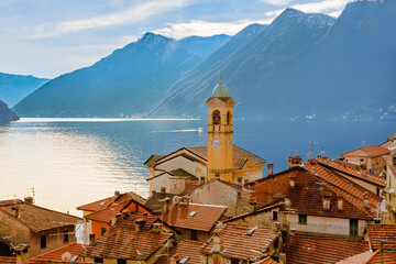 lario 02 - paese sul lago con vista campanile e montagnein controluce.