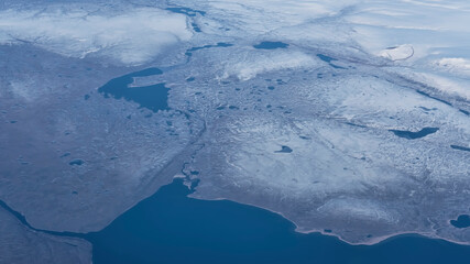 Arial coastal view of the barren land, snow, glaciers and frozen lakes and rivers of south of...