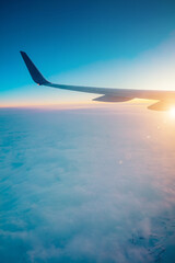 Fototapeta premium Top view from inside window airplane of a sunset sky and wing