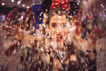 Happy girl is blowing confetti