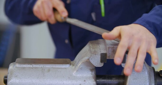 filing iron piece on vice