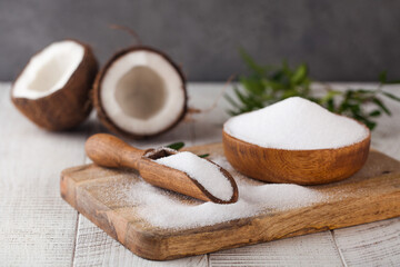 Sugar substitute in a wooden bowl on a background of coconut. Natural sweetener. Stevia, erythritol.