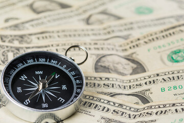 Fototapeta na wymiar Compass with US dollar notes
