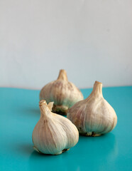 garlic on a turquoise background. garlic harvest of 2020. folk remedy for colds and viruses