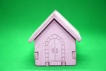 Wooden small children's house on a green background. A toy.