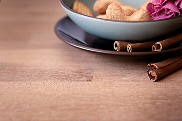 Fresh cookies with cinnamon sticks on pate on a wooden background
