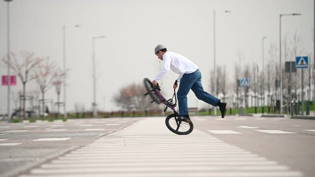 Young man performing tricks with a flatland bmx bike