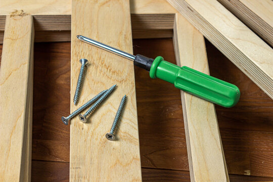 Woodwork. Wooden slats and working tools. Metal screw and screwdriver.