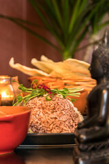 An assortment of Sri Lankan dishes like red rice, papadam bread, and a Buddah amulet.