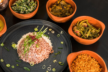 An assotment of Sri Lankan dishes like red rice and different pickles.