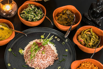 An assotment of Sri Lankan dishes like red rice and different pickles.