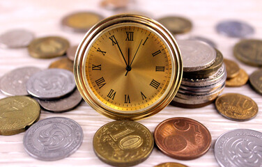 Small watches and coins on a light background. Time is money concept