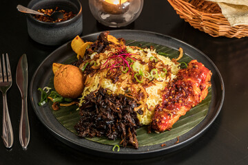 A Sri Lankan dish called Pamprais, a fried chicken leg and fish served on banana leaf.