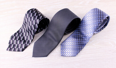 Three gray men's ties on a light background. Male accessory