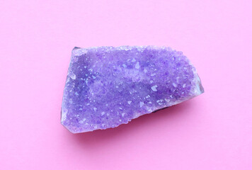 Beautiful druse of natural purple mineral amethyst  on a pink background. Large crystals of...