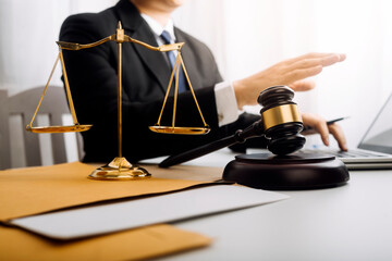 Justice and law concept.Male judge in a courtroom with the gavel, working with, computer and...