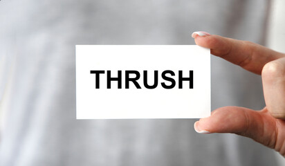 On the card text THRUSH, the girl holds a business card in front of her.