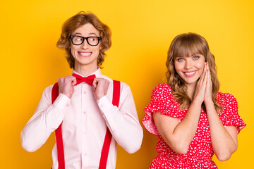 Portrait of cheerful guy fix bow look interested adorable lady folded hands palms isolated on yellow color background