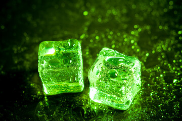 Green ice cubes reflection on black table background.