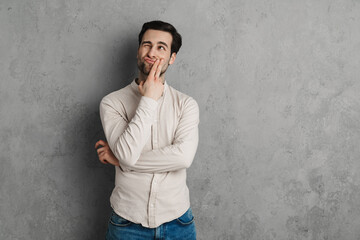 Handsome young man in casual outfit looking up isolated