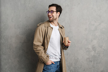 Handsome man wearing stylish coat posing isolated