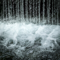Nahaufnahme von einem Wasserfall über eine Staustufe