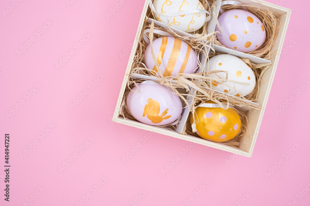 Poster top view of painted easter eggs on a box with straw isolated on pink background with copy space